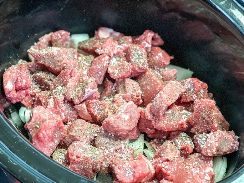 Stew meat in a crockpot with onions, salt and pepper. 
