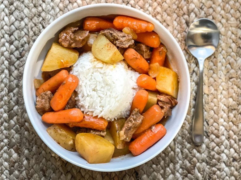 Beef stew with carrots, onions, potato and white rice. 